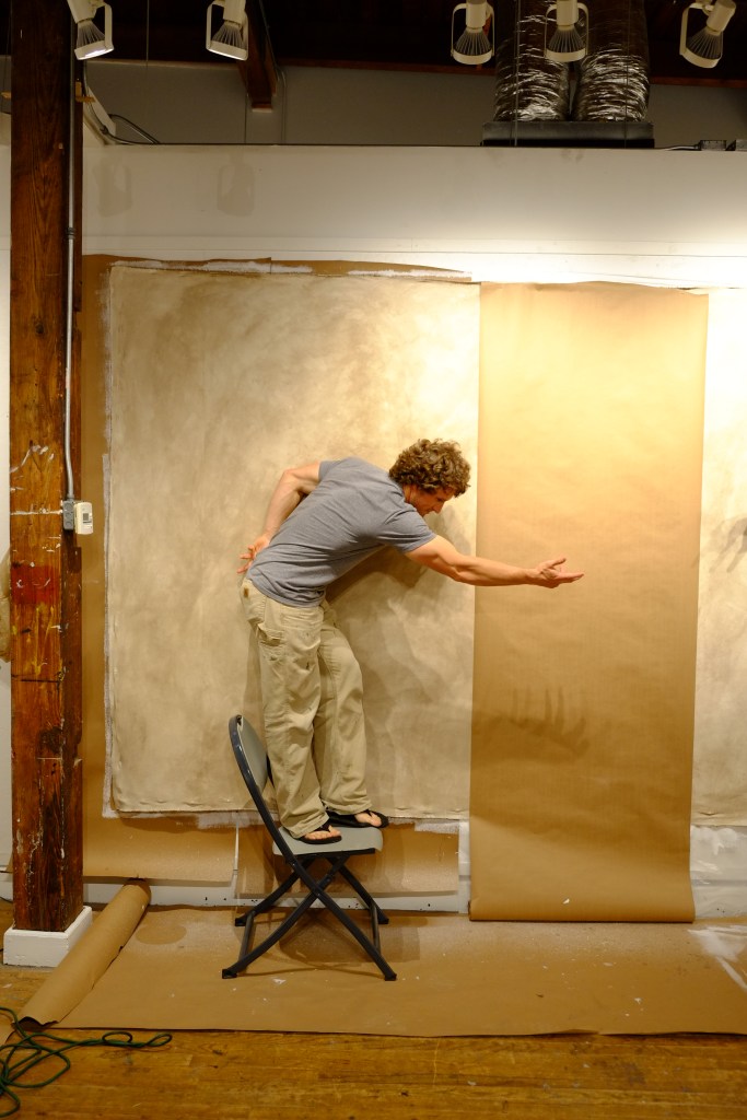 Danen in front of his giant canvas.